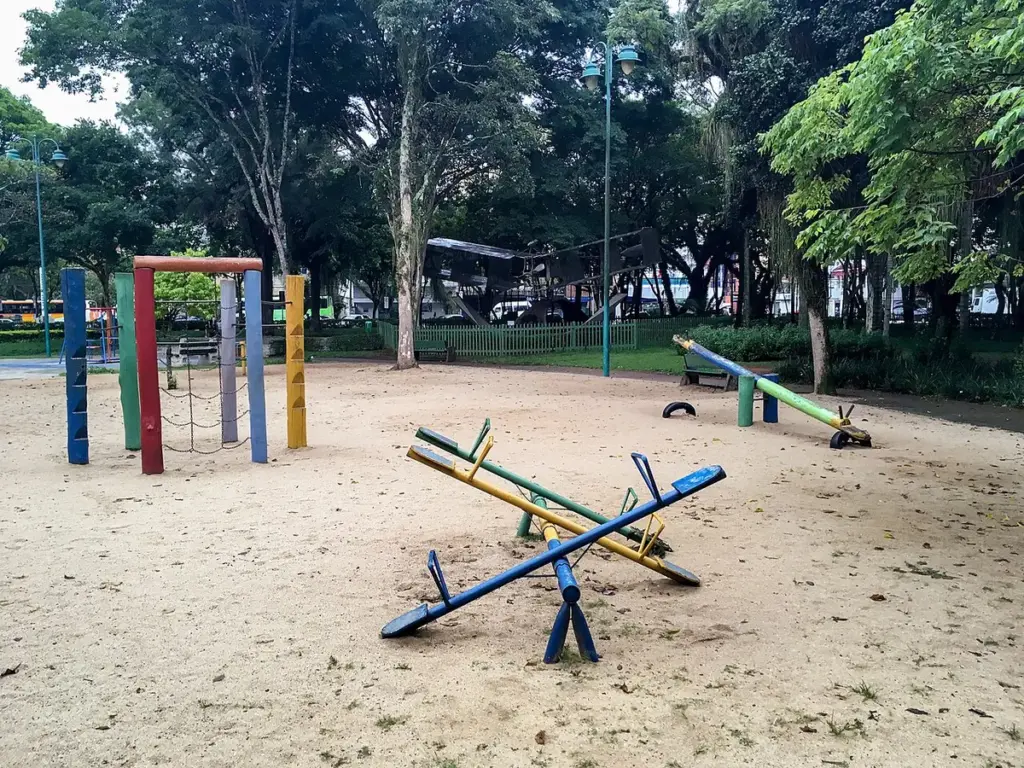 Parquinho infantil com gangorra e brinquedos sobre a areia