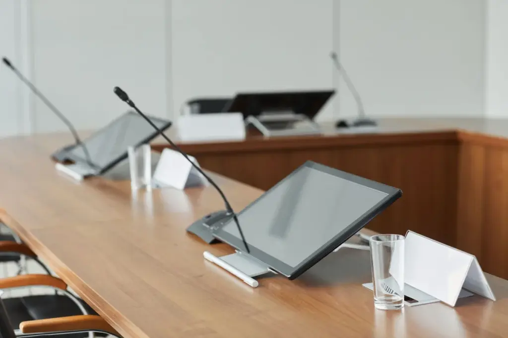 Microfones e equipamentos em uma mesa de reunião