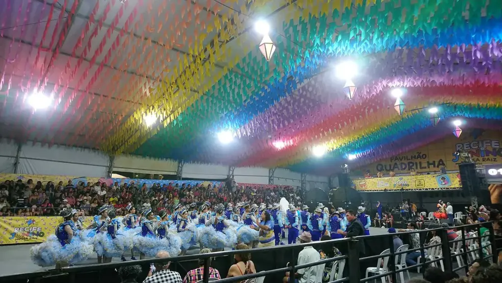Grupo de quadrilha junina com roupas coloridas se apresentando numa festa no RN