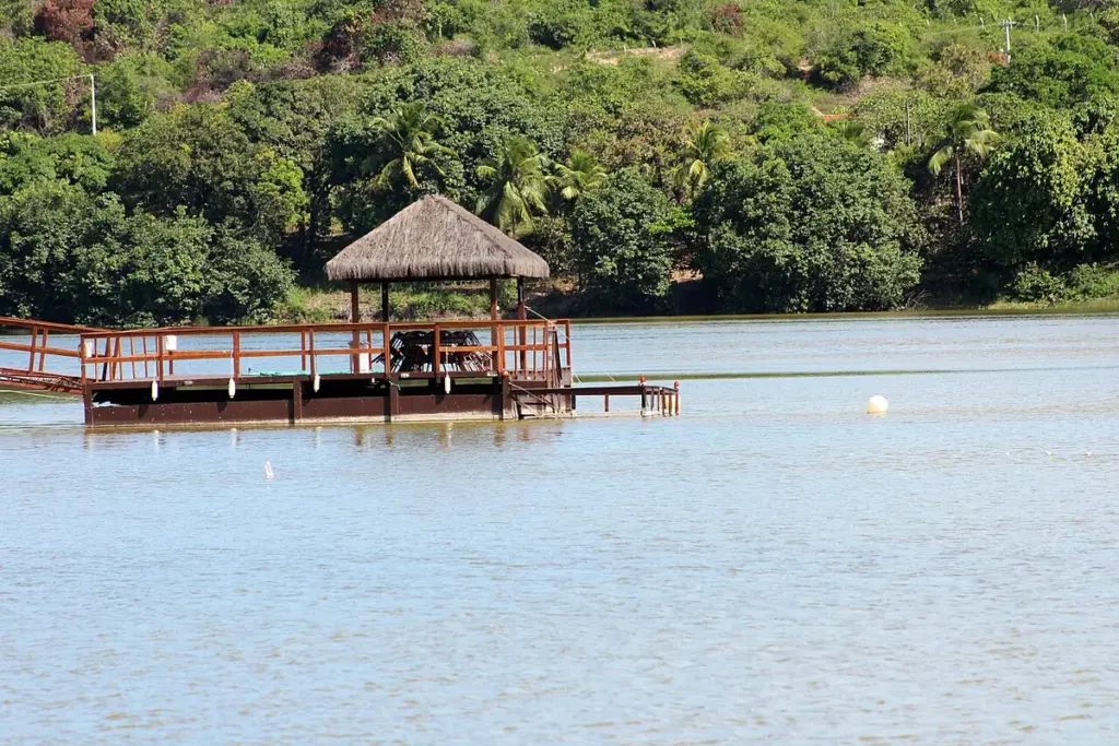 Píer de madeira com quiosque de palha sobre a Lagoa de Extremoz, cercada de mata