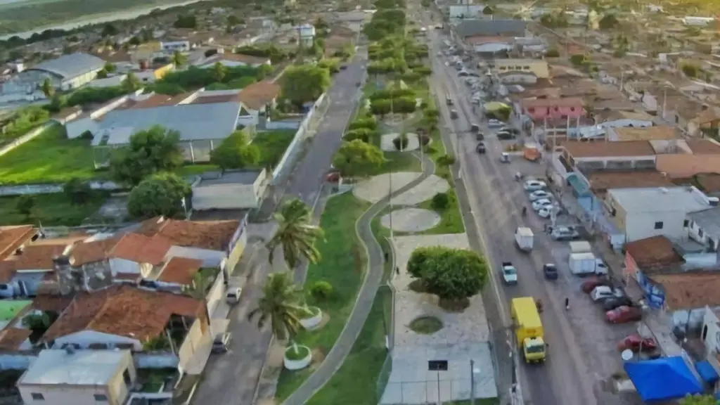 Vista aérea de uma área urbana de Extremoz, com casas, vias e um espaço arborizado central